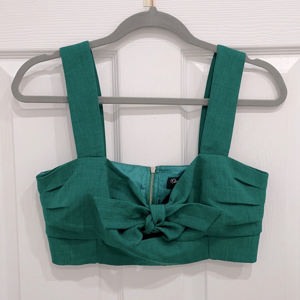 Green bustier crop top with bow detail and decorative silver zipper.